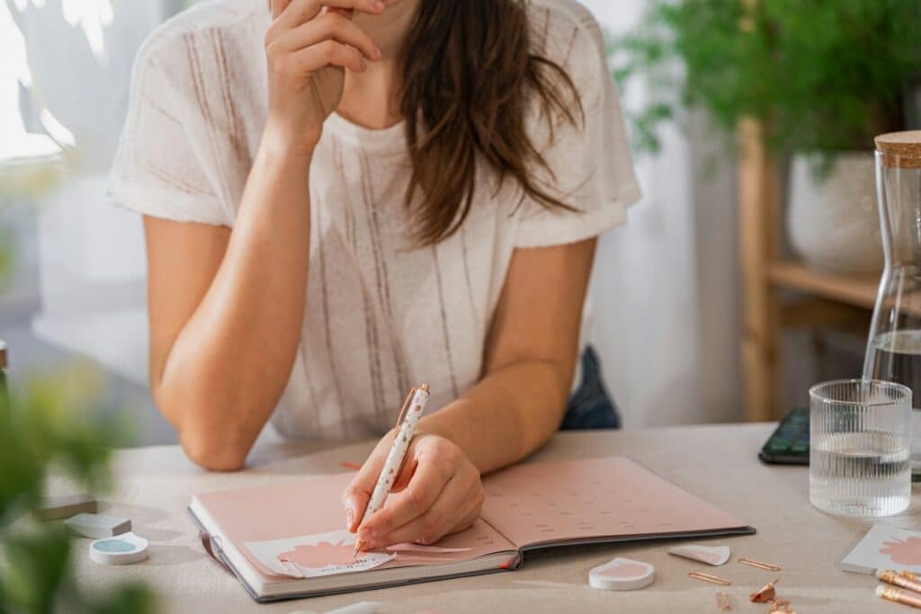 Woman writing in journal after reflecting on how she is living in balance using