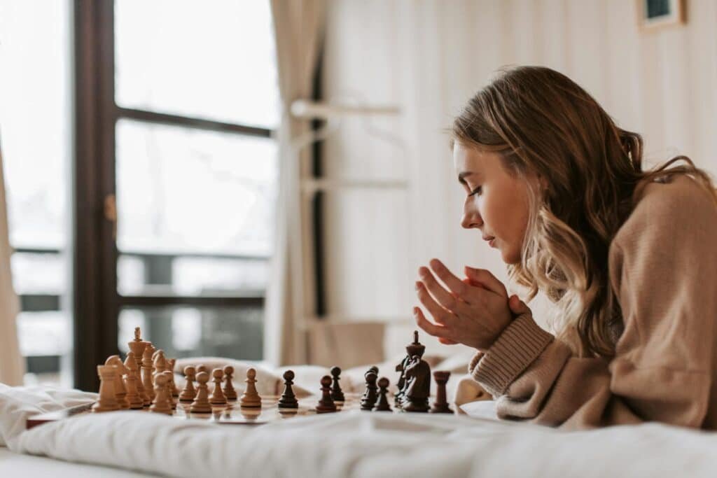 Woman playing chess, representing deciding on next move for trying out different types of hobbies.