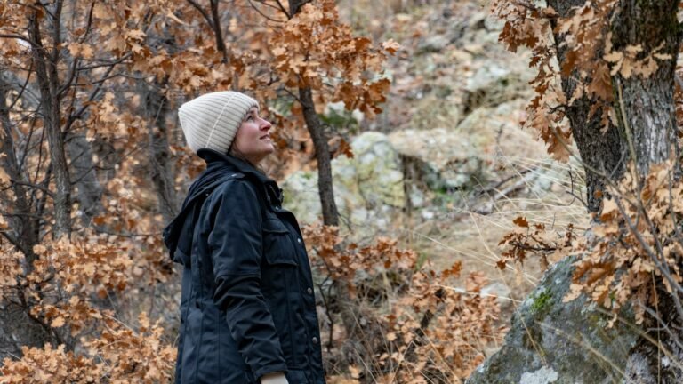 Woman walking outside in the autumn time looking reflective about how to use the seasons to reset your life