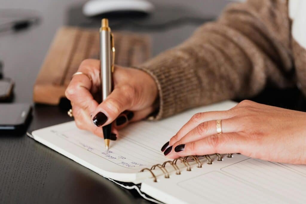 Woman writing in a notebook, making a plan to live intentionally