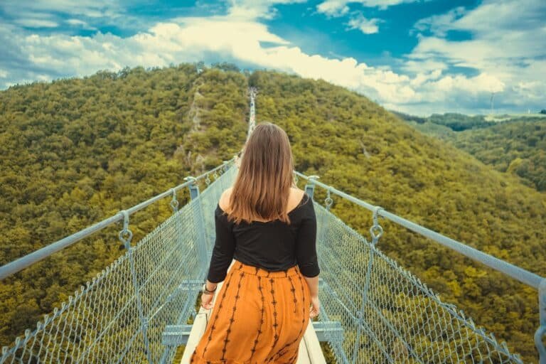 Woman walking across a bridge, reflecting on life after saying yes to everything