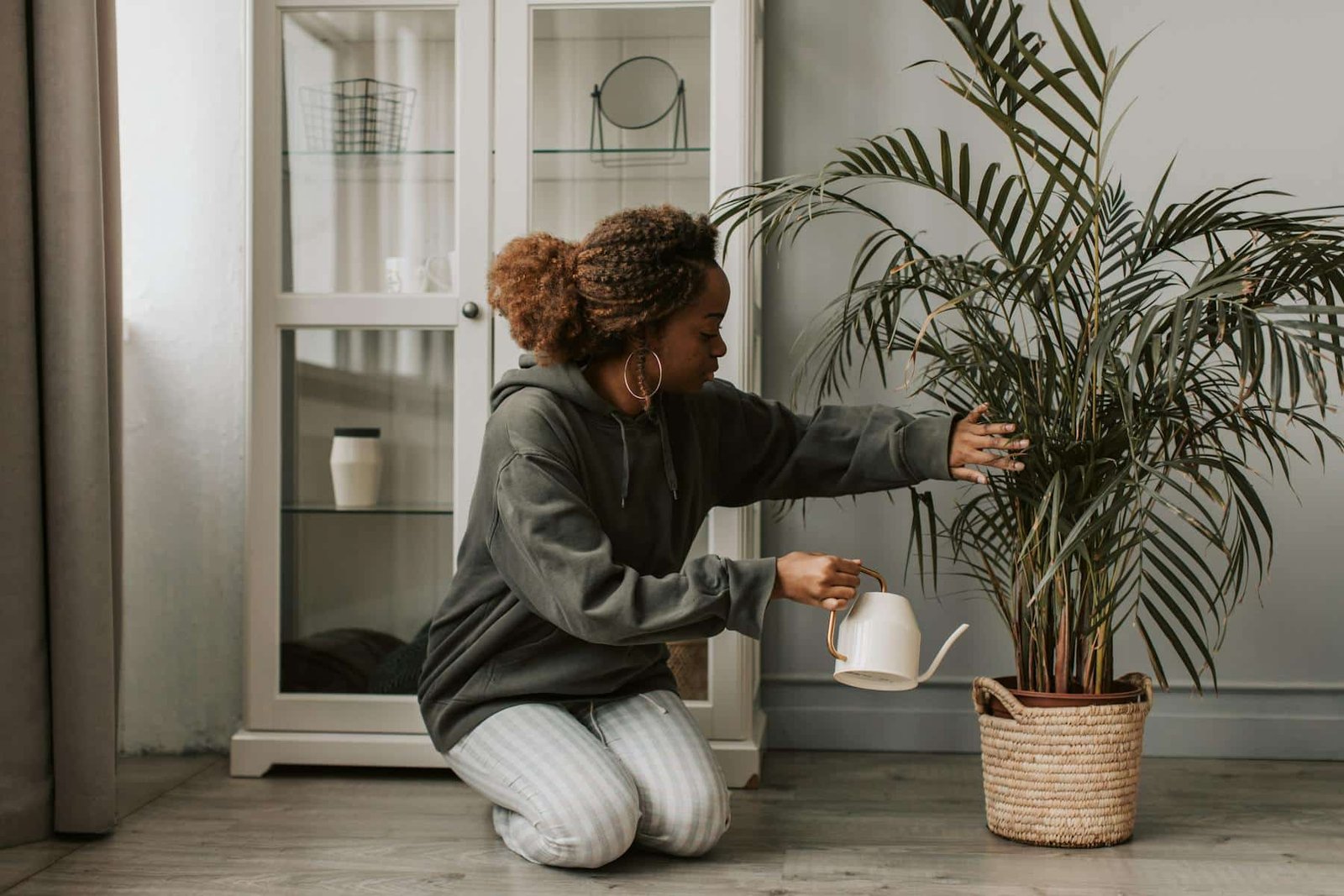 Woman watering a plant as a way to live intentionally and nurture her daily habits
